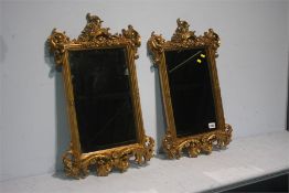 A pair of ornate gilt wall mirrors.