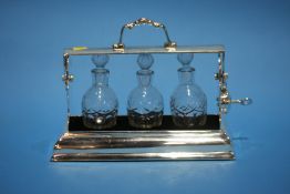 A small plated three bottle Tantalus.