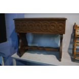 A small carved oak box seat