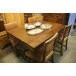 A heavily carved oak drawer leaf table and four oak chairs