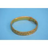 A 9ct gold engraved bangle. Weight 10.8 grams