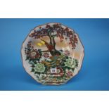 An Oriental dish decorated with birds, flowers and trees