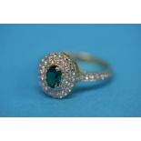 An encrusted diamond ring with central paste emerald