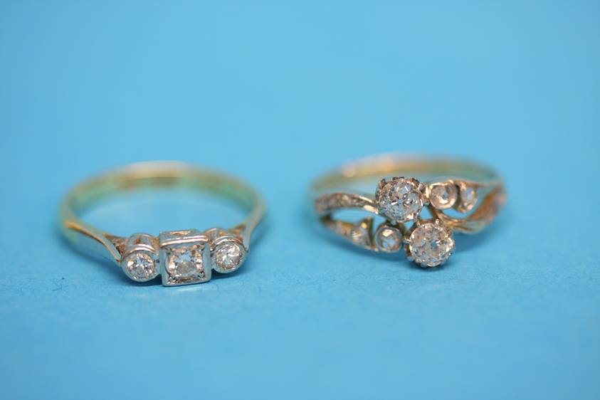 An 18ct gold diamond crossover ring and an 18ct gold diamond three stone ring