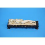 A carved Ivory figure of a female nude lying down