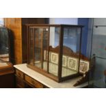 An oak table top shop display cabinet with glass s