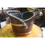 A mahogany coal bucket with copper bands and rope