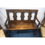 A 1920's carved oak hall settle