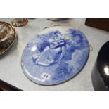 A blue and white oval ceramic plaque