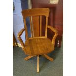 A 1930's oak swivel and rocking desk chair, with solid seat