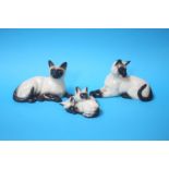 Two Beswick Siamese cats and a Royal Doulton cat