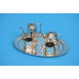 A miniature silver child's tea service. Comprising of; tray, cream and sugar bowls, a water pot