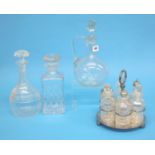 A silver plated six bottle cruet and three clear glass decanters.