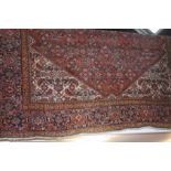 A Persian carpet, the large pink ground bearing a central medallion with allover floral design, with