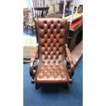 A brown leather button back Chesterfield armchair