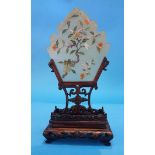 An Oriental table screen on a carved hardwood stand