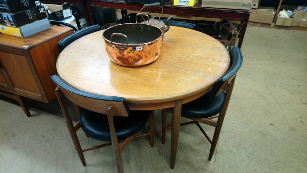 A teak circular table and four dining chairs