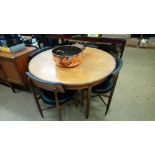 A teak circular table and four dining chairs