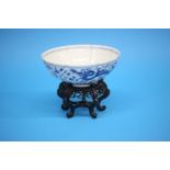 A chinese blue and white dragon bowl, various labels to base, on original stand 21 cm diameter and