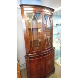 A reproduction mahogany corner cabinet