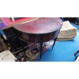 A mahogany half moon fold over card table