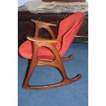 A Danish teak rocking chair with open and curved arms, having a padded back and seat and a similar