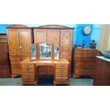 A four piece pine Ducal bedroom suite comprising dressing table, wardrobe, gents wardrobe and