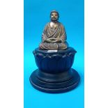 A gilt wood Buddha, resting on carved wood lotus flower 28 cm Height