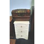 A cream chest of drawers and a standard lamp