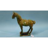 An Oriental figure of a horse decorated in green glaze (a/f)