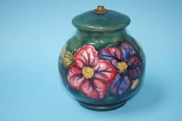 A Moorcroft table lamp of globular form on a green