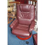 A burgundy leather armchair and footstool