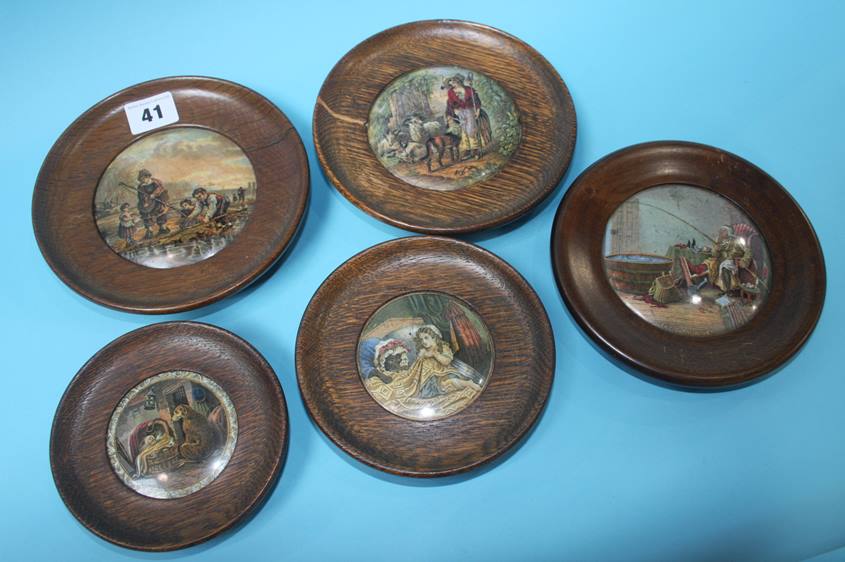 A collection of five pot lids in oak frames