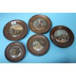 A collection of five pot lids in oak frames