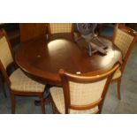 A modern mahogany circular extending dining table and four chairs