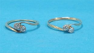 Two gold two stone diamond cross-over rings.