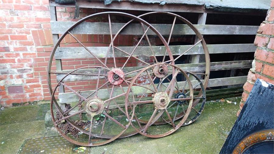 Two pairs of Ironwork wagon wheels and a single wheel.