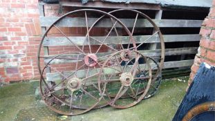 Two pairs of Ironwork wagon wheels and a single wheel.