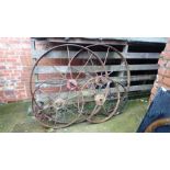 Two pairs of Ironwork wagon wheels and a single wheel.