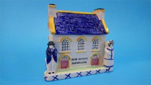 A 19th Century Staffordshire house money box, with two figures standing either side of the house, to
