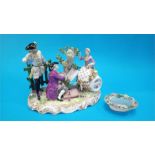 An early 20th Century German (Dresden) porcelain group of two Gentlemen and a Lady seated on a