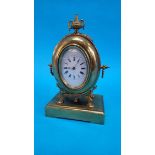A small brass mantel clock with oval enamelled dial, stamped S. and F. 23cm high