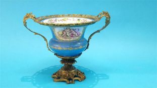 A Continental Sevres style vase on a gilt metal ornate mount. 25cm high 35cm wide