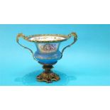 A Continental Sevres style vase on a gilt metal ornate mount. 25cm high 35cm wide