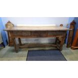 An 18th Century Spanish (?) walnut refectory table, with carved frieze, three drawers and a secret