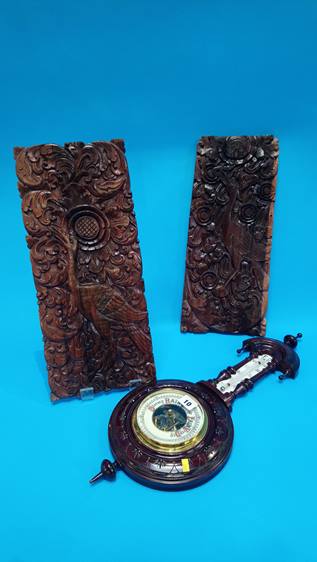 A pair of carved panels and a barometer.