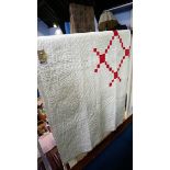 A white Durham quilt, with red patterned reverse.