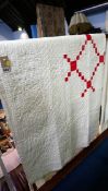 A white Durham quilt, with red patterned reverse.