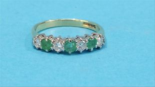An 18ct gold diamond and emerald seven stone ring.