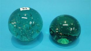 Two Victorian green glass door stops with bubbles.